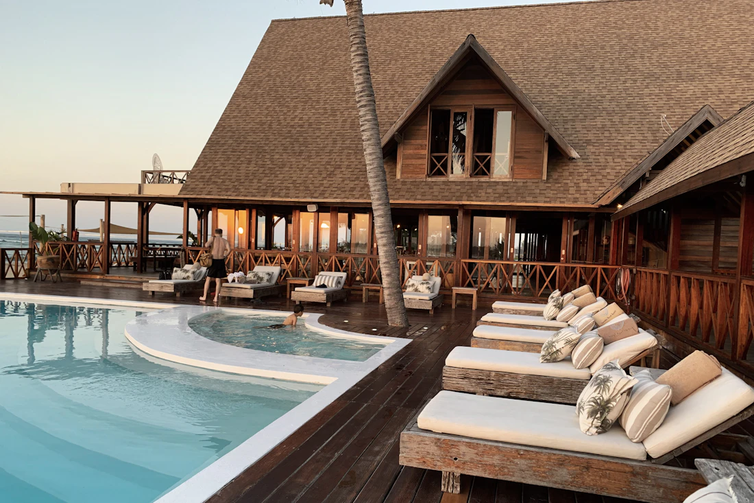 Terrasse en bois et piscine d'un hôtel au coucher du soleil